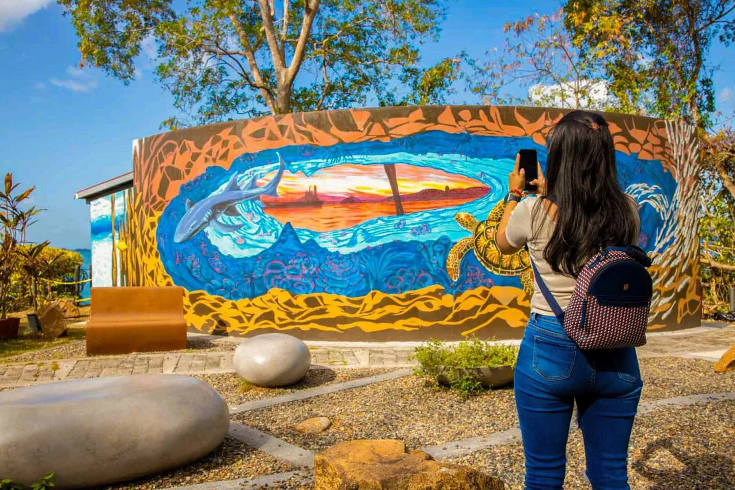 Visitor viewing a colorful marine mural at Punta Culebra Nature Center